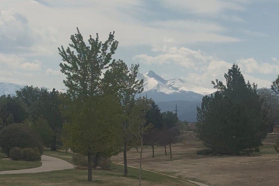Snow-capped Rocky Mountain peaks on the horizon near Alpine Crossing in Longmont, Colorado